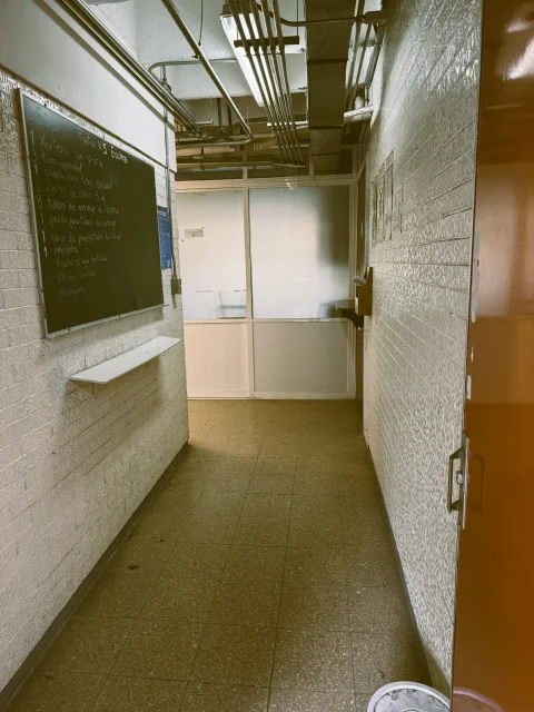Pasillo del edificio L-5 en la actualidad, con el pizarrón de una práctica de laboratorio