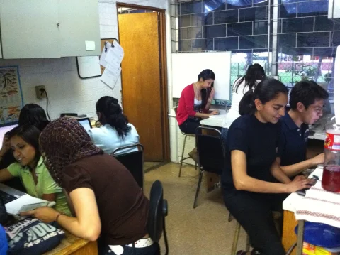 Estudiantes trabajan en las mesas del laboratorio junto a las peceras.