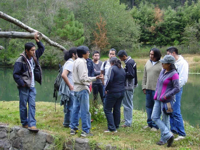 Grupo durante una práctica de campo junto a estanques de cultivo.