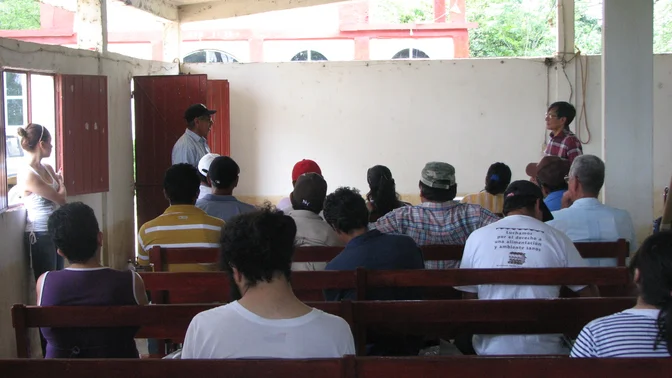 Grupo escucha una explicación durante un taller comunitario.